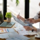 Two business partnership coworkers discussing a financial planning graph and company during a budget meeting in office room.