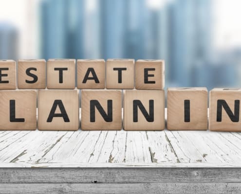 Estate planning sign on a wooden pier with tall buildings in the background