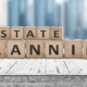 Estate planning sign on a wooden pier with tall buildings in the background