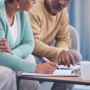 Senior couple, documents and sign contract for life insurance or home mortgage. Discussion, signature and retired elderly man and woman signing legal paperwork for will or loan application together.