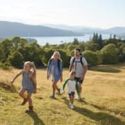 Family Climbing Hill On Hike Through Countryside In Lake District UK Together