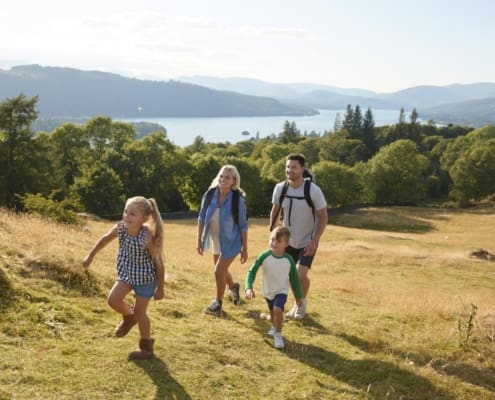 Family Climbing Hill On Hike Through Countryside In Lake District UK Together