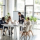 multiethnic businesspeople at table with laptops during conference in office