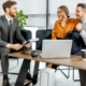 Happy young couple having a great deal with financial advisor or real estate agent at the luxury office. Investment, lending or or successful resolution of legal issues for a young family