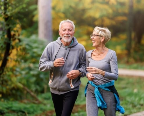 Smiling senior couple jogging in the park