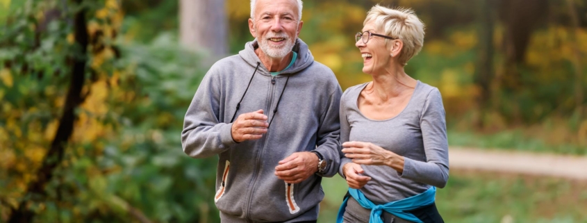 Smiling senior couple jogging in the park