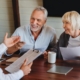 Happy aged couple consulting with insurance agent at home