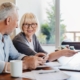 Senior couple doing home finances using laptop indoors