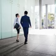 Asian business people discussing while walking