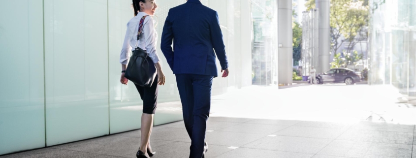 Asian business people discussing while walking