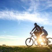 Happy mountain bike couple outdoors have fun together on a summer afternoon sunset.