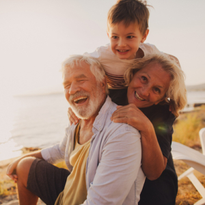 Photo of a little boy and his grandparents having a picnic by the seaside