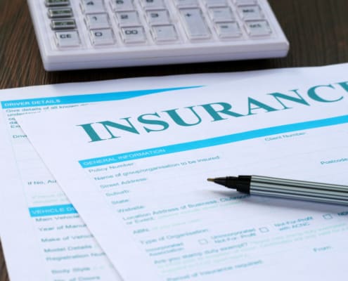 insurance form, calculator and pen on the table